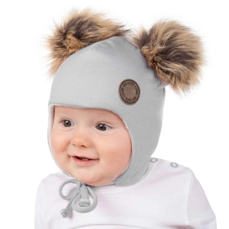 Warme en stijlvolle babymuts van merinowol met pompons van imitatiebont.